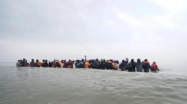 تصویری از ده‌ها پناهجو در میان آب‌