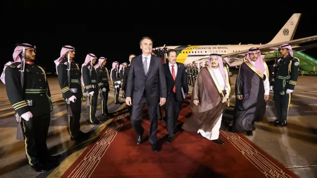 Bolsonaro saindofutebol virtual betavião brasileirofutebol virtual bettapete vermelho, rodeado por homens com trajes típicos da Arábia Saudita