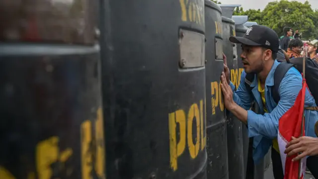 Sejumlah pengunjuk rasa berdiri di depan barikade polisi di depan kompleks Parlemen, Senayan, Jakarta, Kamis (22/8/2024).