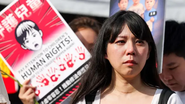 台湾一名女性参与游行，诉求政府正视儿虐案件。