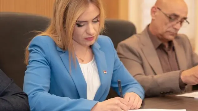Milica Đurđević Stamenkovski u plavom sakou se potpisuje