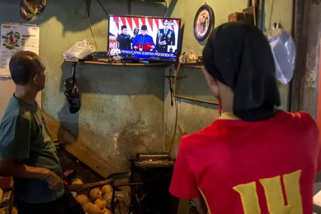 Pedagang menonton siaran langsung prosesi pelantikan Presiden dan Wakil Presiden periode 2024-2029 di Pasar Antri Baru, Kota Cimahi, Jawa Barat, Minggu (20/10).