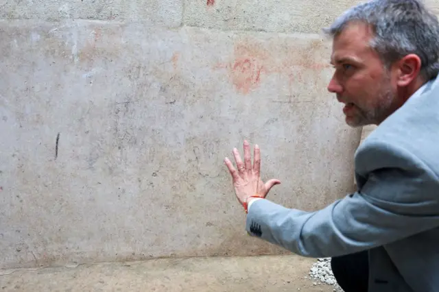 El director del parque arqueológico, Gabriel Zuchtriegel, junto al dibujo de una mano pequeña en la pared.