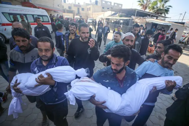 Des personnes transportent les corps de deux enfants tués lors d'une frappe aérienne israélienne vers l'hôpital des Martyrs d'Al-Aqsa à Deir al-Balah, au centre de la bande de Gaza, le 12 novembre 2024. (Photo de Majdi Fathi/NurPhoto via Getty Images)