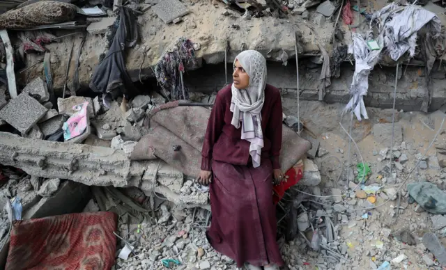 गाजामा भग्नावशेष सामु एक युवती