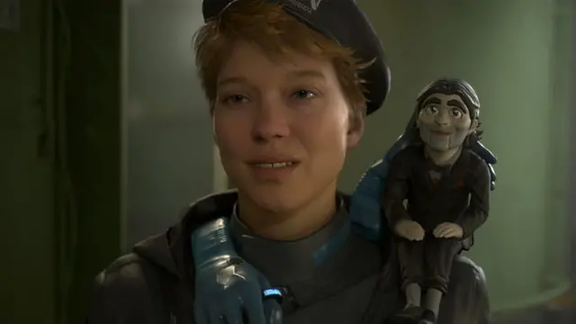 Cena de 'Death Stranding 2' com uma mulher e um boneco de ventríloquo no ombro
