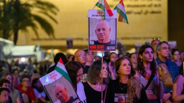 Группа людей на демонстрации держит плакаты с портретом Илана Вайса и надписью Bring him home now.