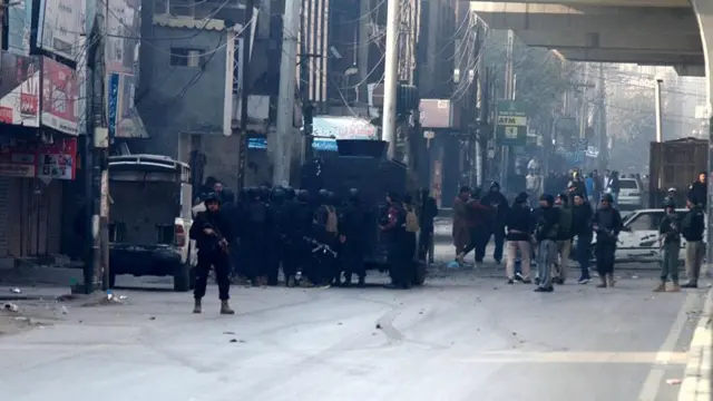 تصویر محل حمله در پشاور را نشان می‌دهد که شمار زیادی از نیروهای امنیتی و موترها در تصویر دیده می‌شوند.