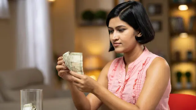 నోట్లు పట్టుకున్న మహిళ