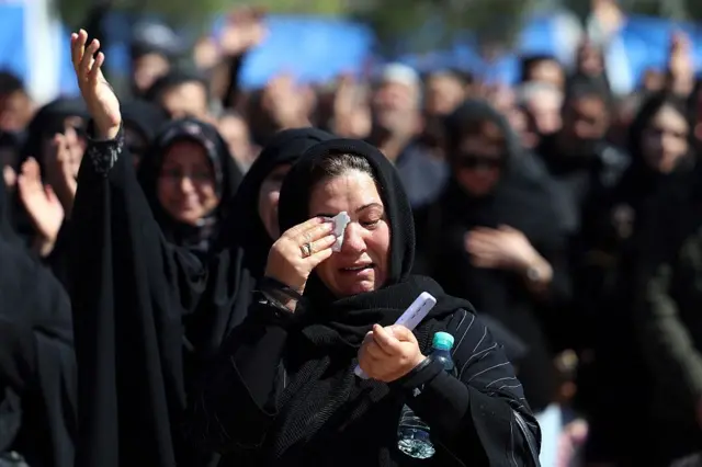 Uma mulher iraniana chora durante o funeral das vítimas.