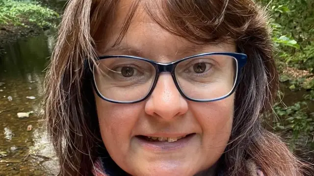 Nicolette sonríe a la cámara. Lleva gafas y el pelo largo y castaño.