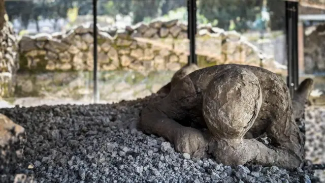 A plaster cast of a body lying on the ground at Pompeii 