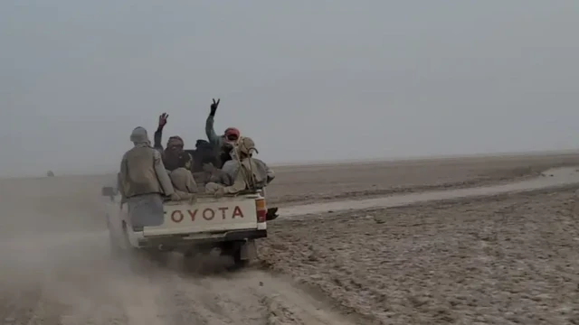 یک خودروی وانت که پشت آن چند نفر نشسته اند