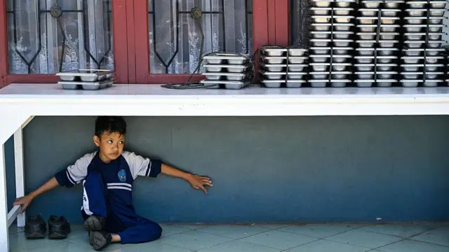 Seorang siswa menunggu makanan yang disediakan oleh program makan gratis di sebuah sekolah dasar di Banda Aceh pada 30 Oktober 2025.