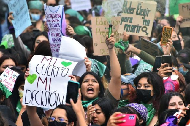 Mujeres con pancartas, una de ellas dice: "Mi cuerpo, mi decisión"