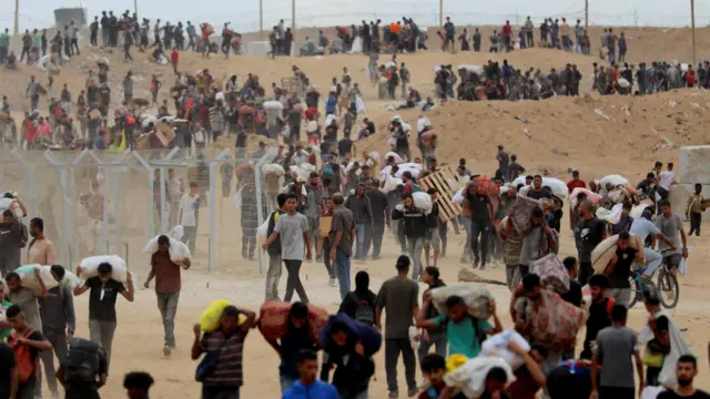 أهالي غزة يحملون أكياس الطحين في مشهد يعكس جهودهم في توفير الاحتياجات الأساسية لأسرهم.