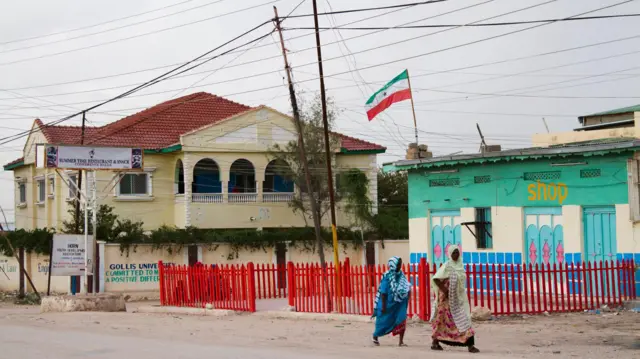 жінки закутані в хустки йдуть по вулиці міста Харгейса, на одній із будівель видно прапор Сомаліленду