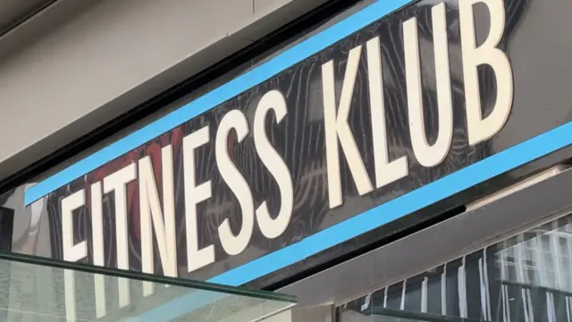 Spolszczenie 'fitnes klub' na szyldzie budynku