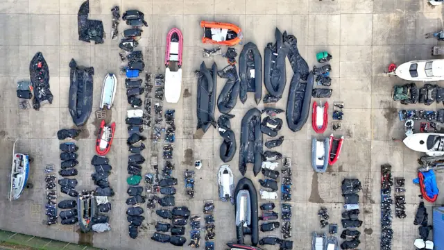 A view from above of small boats and outboard motors in various states of disrepair used by people thought to be migrants to cross the Channel at a warehouse facility in Dover, Kent. 