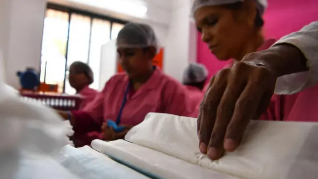 Indian employees at the Myna Mahila Foundation prepare sanitary pads at their office in Mumbai on April 10, 2018. 