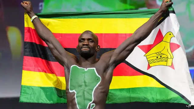 Themba Gorimbo ya zana taswirar Afirka kuma ya ɗaga tutar ƙasar sa ta asali Zimbabwe, a Vegas, ranar Juma'a 6 ga watan Disambar 2024.
