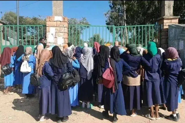 Gabdho arday oo muslimiin ah oo taagan albaabada iskuulka oo xidhan