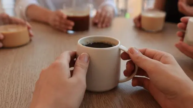 Mesa com várias xícaras e canecas de café e chá