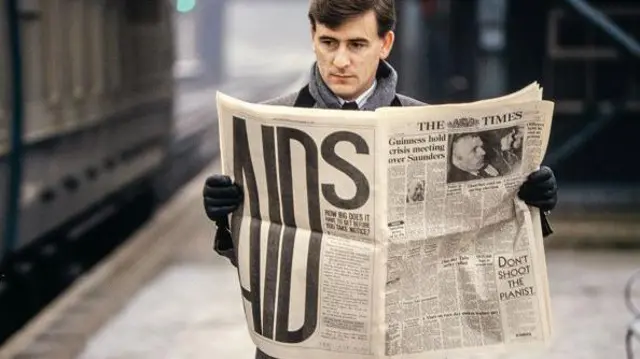 Homem lendo jornal com campanha sobre aids