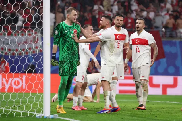 Mert Günok karşılaşmanın son dakikasında kurtardığı top sonrası tebrik ediliyor