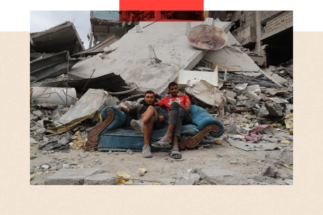 Wanaume wawili wanaonekana hapa wakiwa wameketi mbele ya vifusi vya jengo liliporomoka huko Gaza
