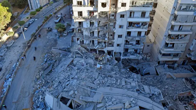 عکسی از نمای بالا، آوار یکی از شعبه‌های قرض‌الحسن و آسیب‌دیدگی ساختمان‌های اطراف