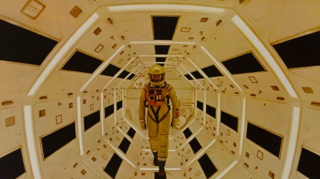 صحنه‌ای فیلم «۲۰۰۱: یک ادیسه فضایی» فردی با لباس فضایی درون محفظه‌ای راه می‌رود