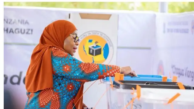 Aarẹ Samia Suluhu lo n dibo yii. O bo ori rẹ pẹlu ibori alawọ erupẹ, o wọ aṣọ alawọ kan naa to ni omi aro lara