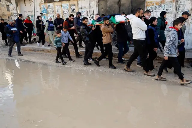 Una procesión llevando el cuerpo de Shatha al-Sabbagh