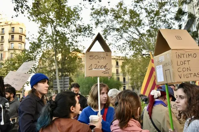 Manifestantes con pancartas, una de las cuales dice: 50 cm cuadrados a 1200 euros al mes