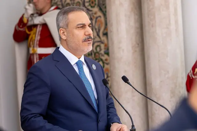 Dışişleri Bakanı Hakan Fidan mavi kravat taktığı bir takım elbiseyle mikrofonların arkasında basın açıklaması yapıyor