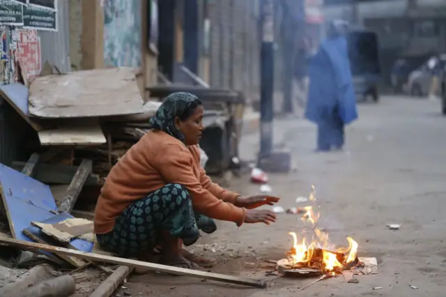 শীত নিবারণ করতে আগুনের তাপ নিচ্ছেন এক নারী। (ফাইল ছবি)