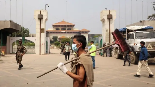 संसद् भवनअगाडि झाडु बोकेर सरसफाइ गर्न जाँदै एक युवा