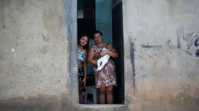 Una madre con un bebé en brazos en la favela de Ciudad de Dios en Rio de Janeiro.