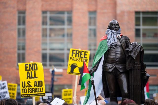تم لف الكوفية والعلم الفلسطيني حول تمثال جورج واشنطن خلال الاحتجاجات في جامعة جورج واشنطن يوم الخميس، 25 أبريل/نيسان 2024.
