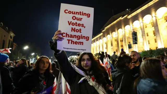 Девушка с плакатом: «Counting Our Voted Not Changing Them» на протесте в Тбилиси 28 октября 2024 года