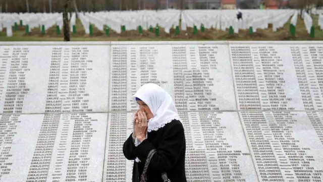 Uma mulher é vista pertobet7k roboum túmulobet7k robofamília no Centro Memorial Potocari, pertobet7k roboSrebrenica, Bósnia e Herzegovina,bet7k robo20bet7k robomarçobet7k robo2019.