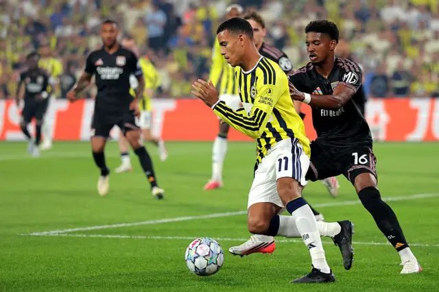 18 Ağustos 2026'da İstanbul, Türkiye'deki Şükrü Saracoğlu Stadyumu'nda Fenerbahçe ile Olympique Lyonnais arasında oynanan UEFA Şampiyonlar Ligi 2026/27 Play-Off turu ilk maçında; Fenerbahçe'den Mason Greenwood ile Olympique Lyonnais'ten Tyler Morton ve Abner Vinicius.