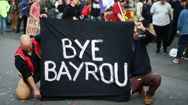 Manifestantes seguram uma faixa com os dizeres "Adeus, Bayrou" enquanto se reúnem para um protesto em frente à prefeitura de Nantes, em comemoração à "festa de despedida de Bayrou". 