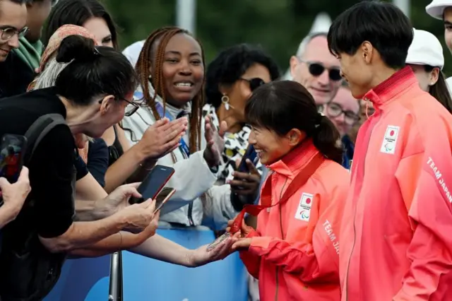 獲得したメダルを観客らに見せる道下