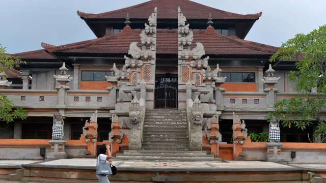 Warga berjalan di depan Gedung Ksirarnawa yang terletak di dalam kawasan Taman Budaya Bali, Denpasar, Bali, Senin (27/3/2023).