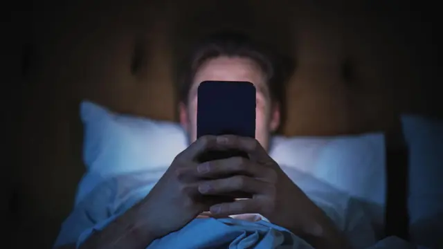 मोबाइल देखता शख्स