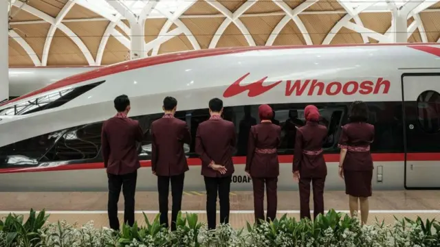 Petugas berdiri di samping kereta cepat Jakarta-Bandung 'Whoosh' usai diresmikan di stasiun Halim Jakarta pada 2 Oktober 2023.