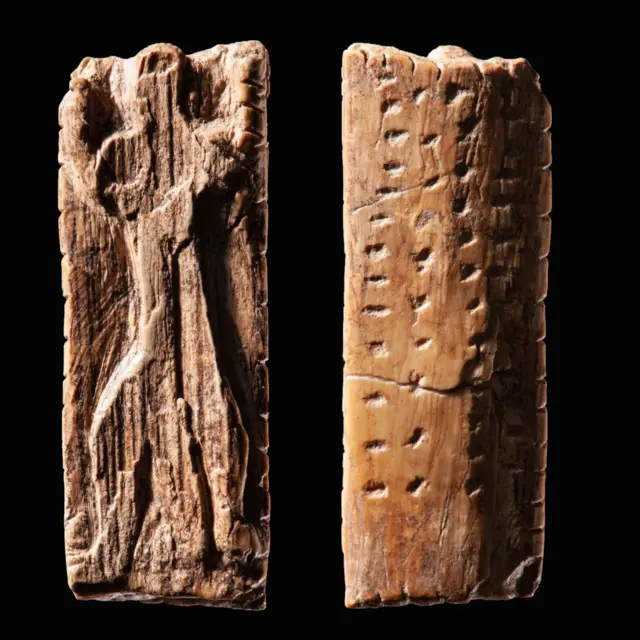 अडोरंट' नावाच्या या कलाकृतीवर मानवी आकृतीसह ठिपके आणि खाचांच्या ओळी कोरलेल्या आहेत.