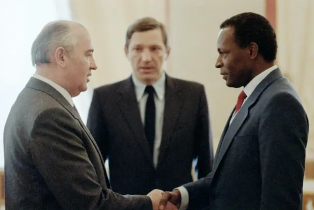 Мужчины в деловых костюмах пожимают друг другу руки